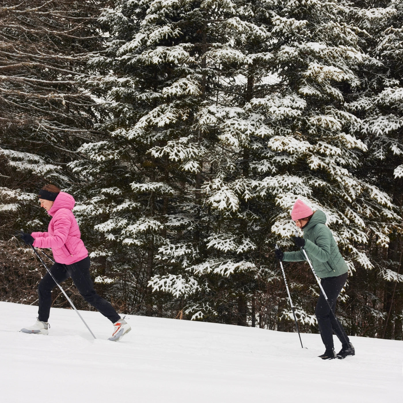 Deux femmes faisant du ski de fond sur piste portant chacune une doudoune légère pour le ski de fond, la course à pied ou la randonnée.