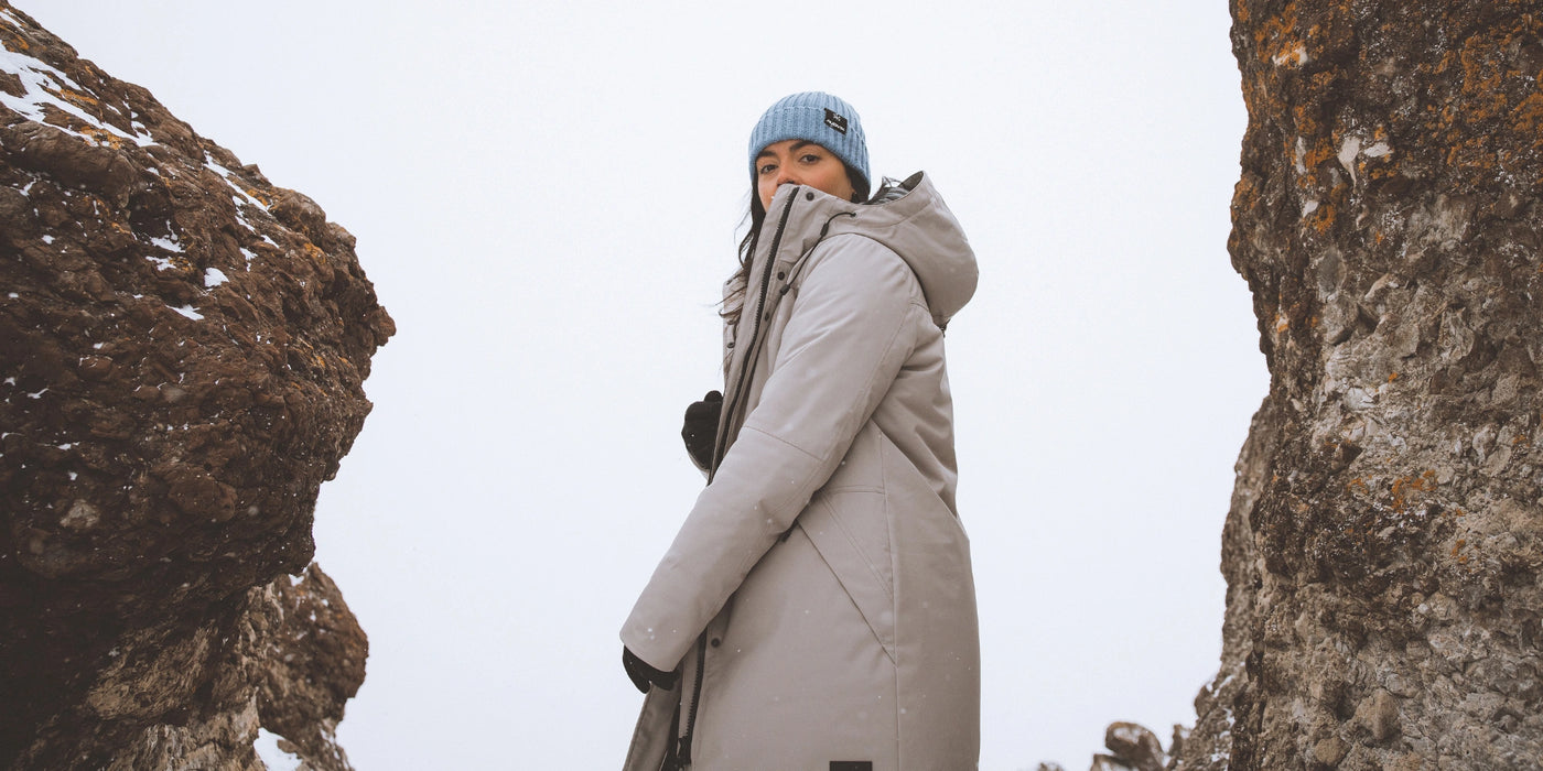 Femme portant une tuque bleue et un manteau beige Audvik fabriqué à Montréal au Québec Canada