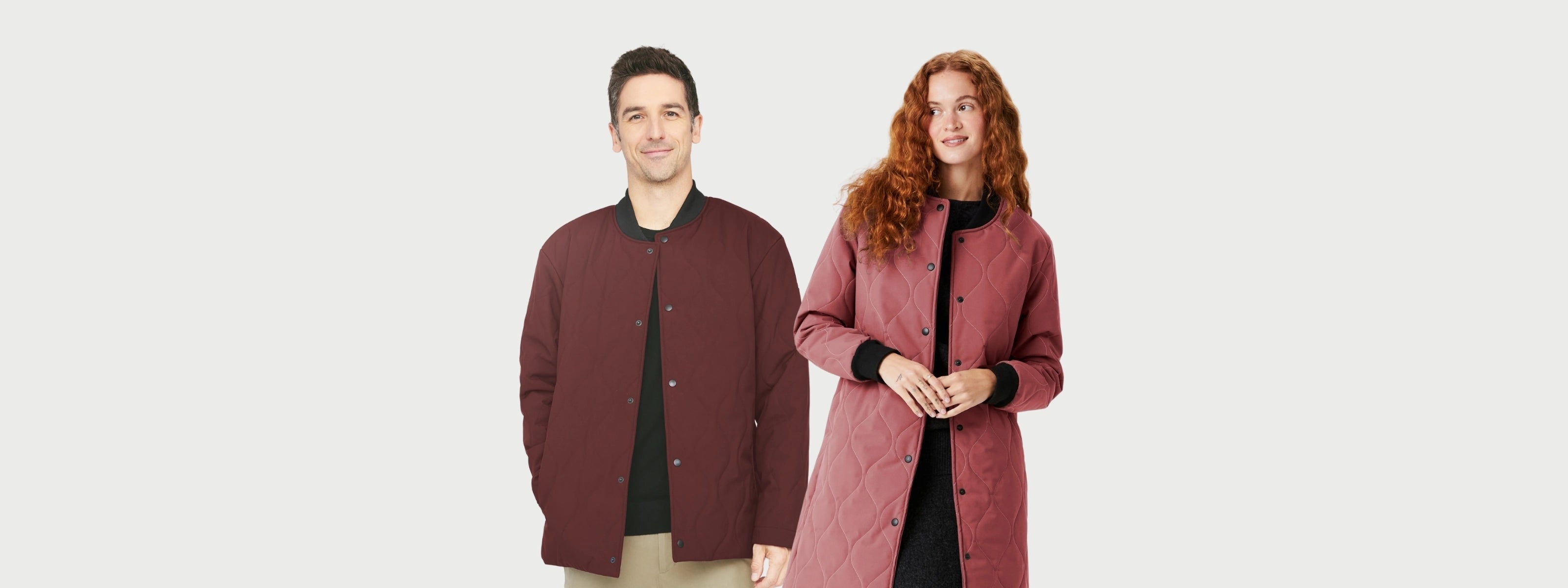 Un homme et une femme sur fond blanc portant chacun un manteau matelassé de mi-saison Audvik. 