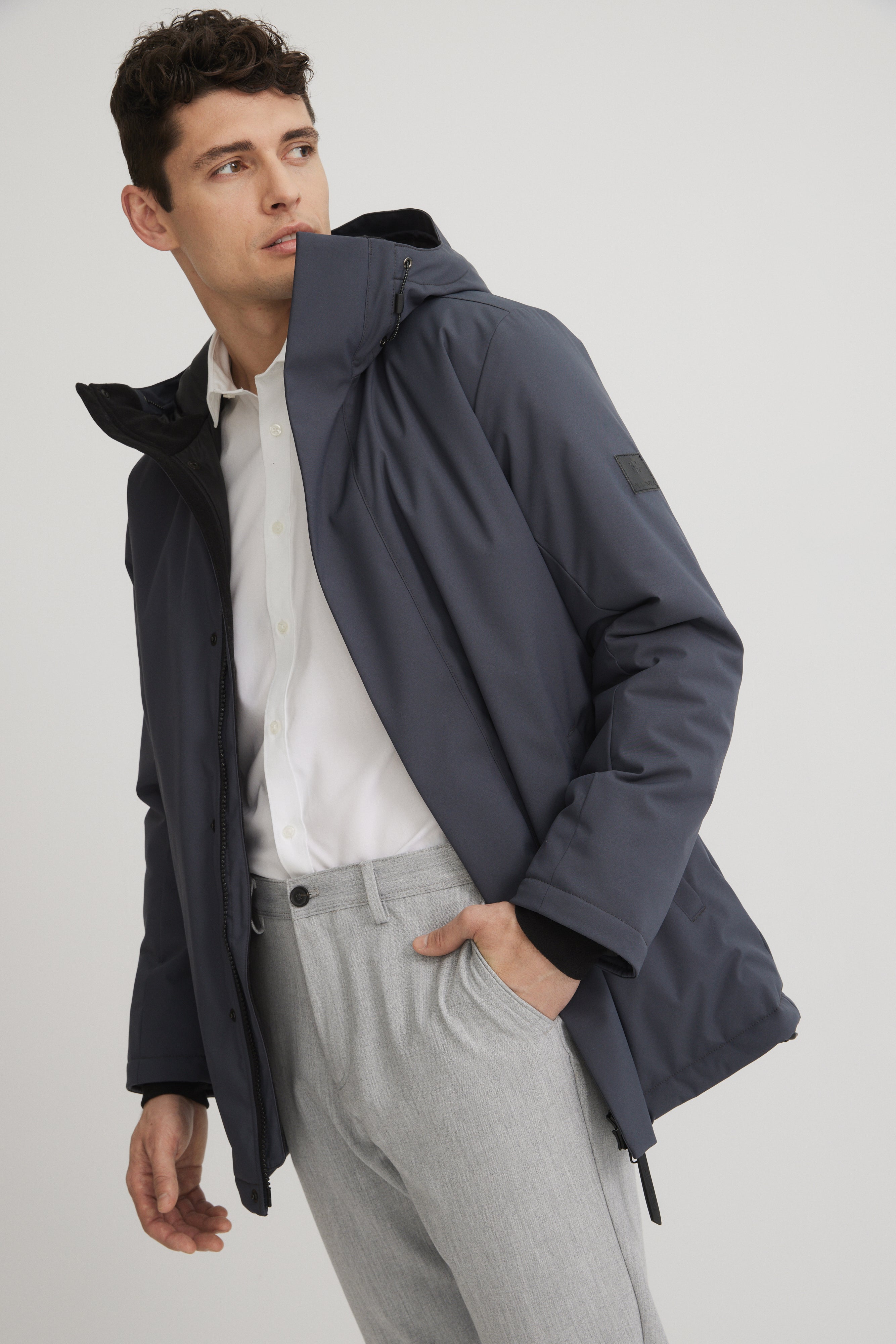 Manteau court chic pour homme couleur gris foncé. Ajustement au capuchon et poignet en micropolar.