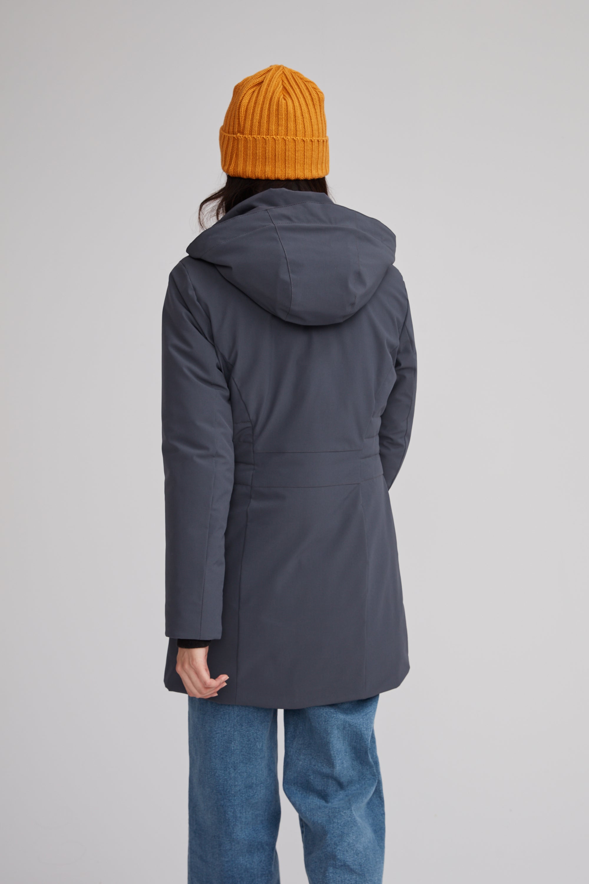 Manteau de couleur gris foncé pour femme avec tuque jaune. Coupe féminine.